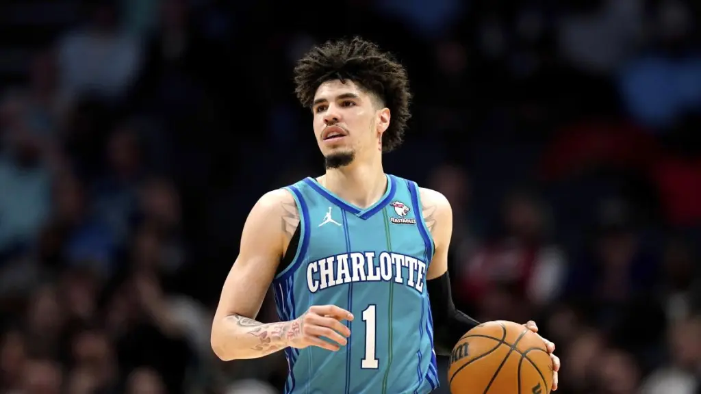 LaMelo Ball穿著夏洛特黃蜂隊的球衣，運球準備進攻，展現出他在2023-2024賽季的成熟比賽風格。